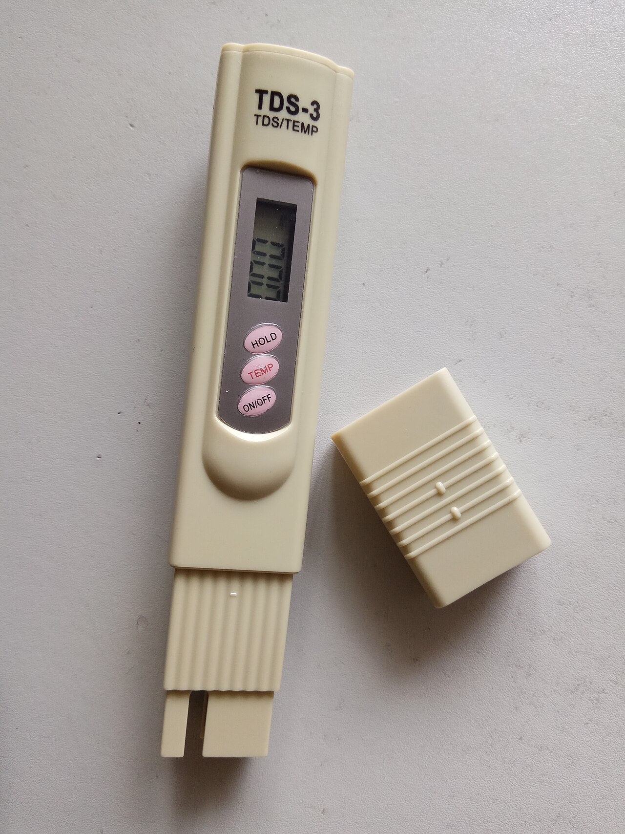 water testing TDS meter probe in glass of water