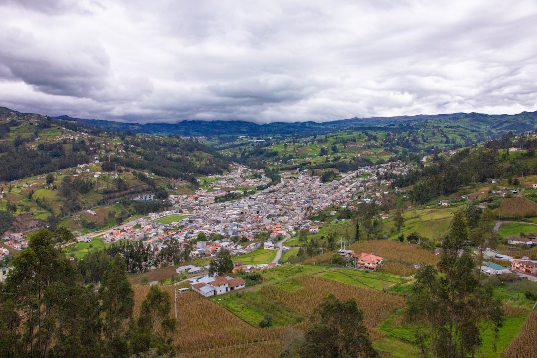 panoramic view of Adjuntas town center plaza, traditional Puerto Rican mountain town architecture, the Sleeping Giant mountain formation visible in the distance