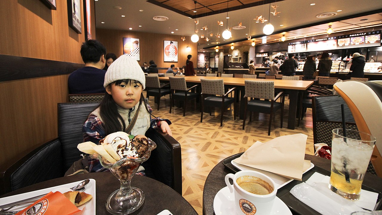 Modern Puerto Rican café interior with customers drinking small cups of black coffee, specialty coffee shop aesthetic, warm lighting