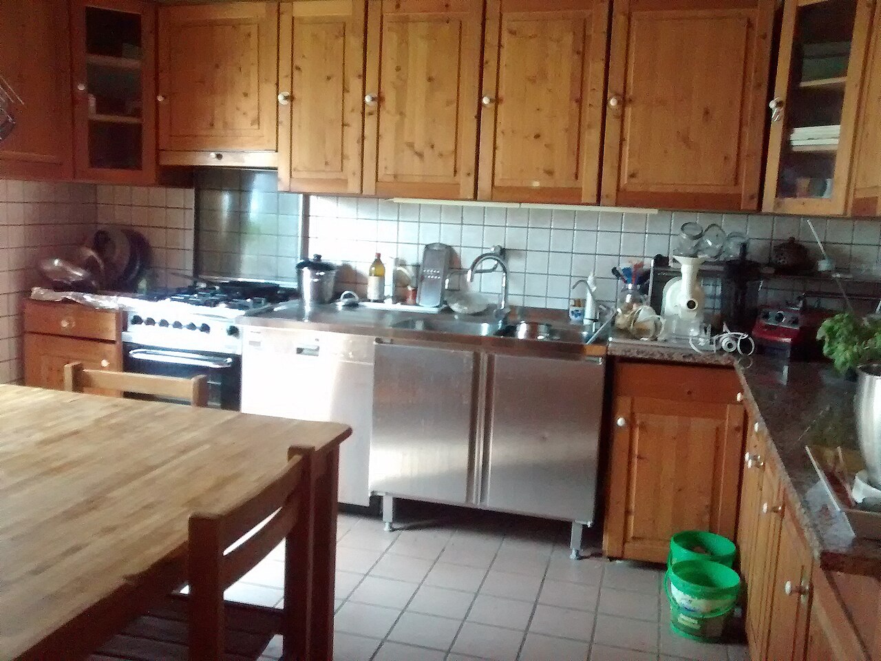 vintage black and white photo style image of a Puerto Rican rural kitchen scene, woman in traditional dress preparing coffee with a colador, wood-burning stove in background