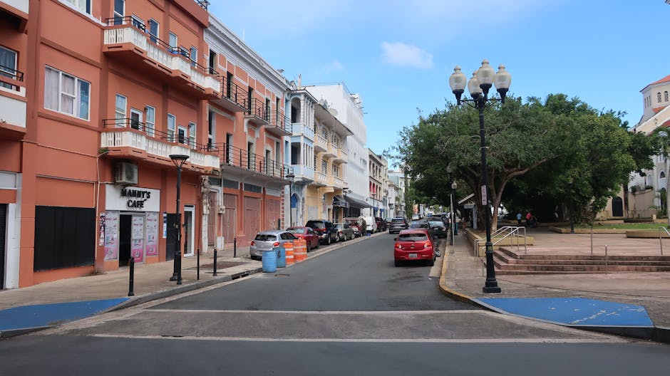 Elderly Puerto Rican woman using pilón in traditional kitchen setting, wearing batik apron, teaching grandchild, multigenerational cultural scene