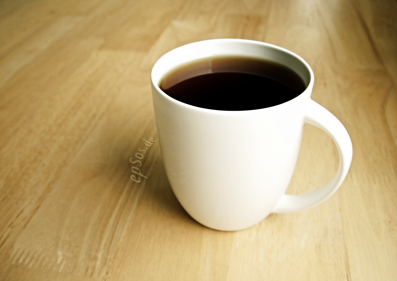 Small ceramic cup of strong black Puerto Rican café puya on rustic wooden table, morning light, steam rising, no cream no sugar