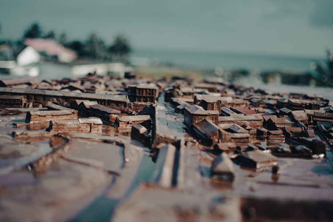 Traditional Puerto Rican wooden pilón (mortar and pestle) with coffee beans inside, on rustic wooden table with Puerto Rican countryside background