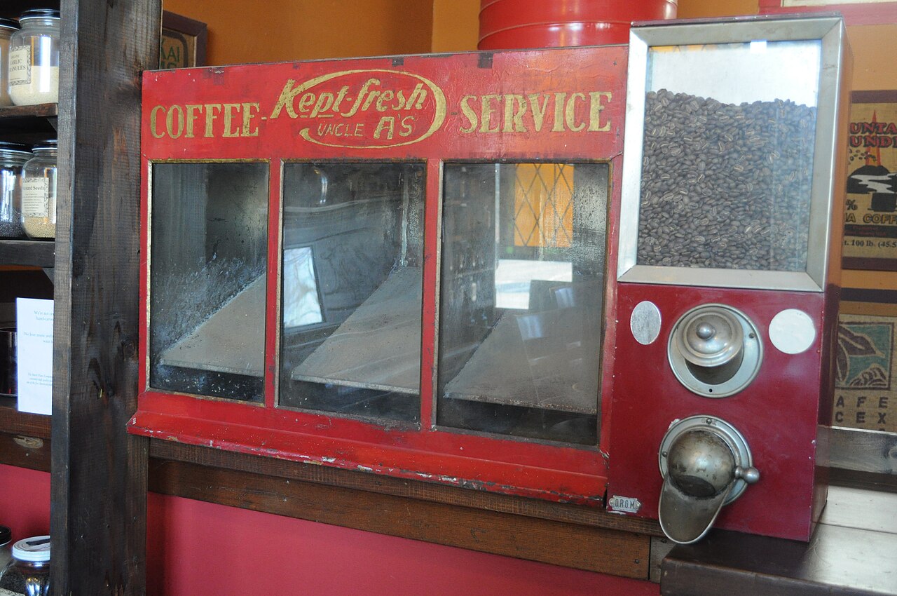 coffee grinder with fresh ground coffee beans on wooden counter