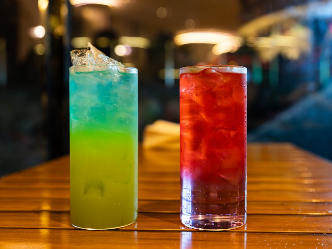 Tall glass of Puerto Rican iced coffee with condensed milk swirl, cinnamon dusting, ice cubes, sunny tropical setting, palm leaf shadow