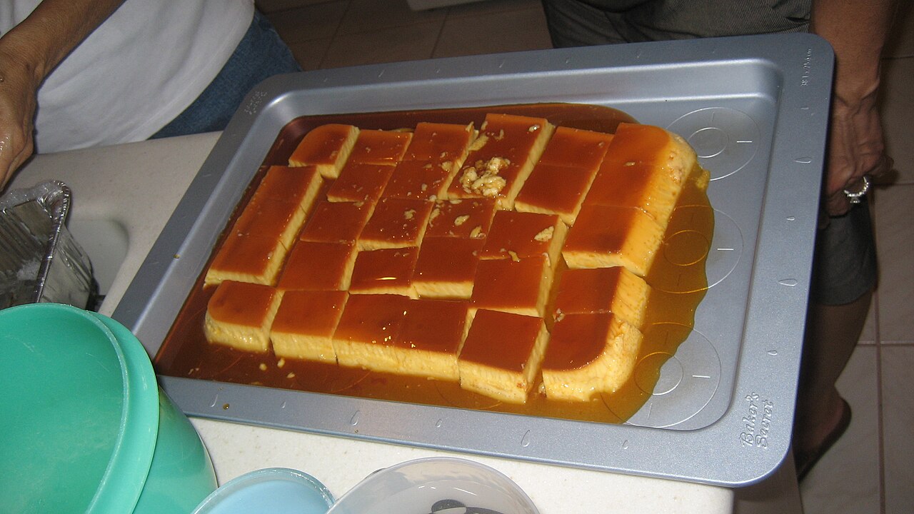 Cross-section slice of flan de café showing smooth coffee-colored custard, amber caramel layer, glistening dessert texture