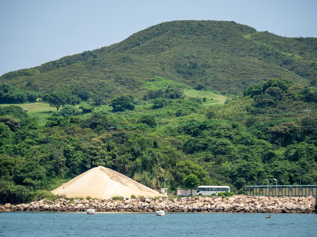 Close-up of triangular piragua cone with dark coffee syrup being drizzled on top, showing the characteristic pyramidal shape