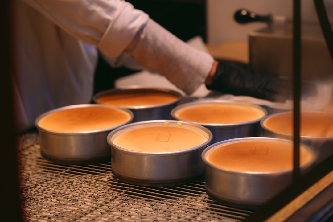 Flan being carefully inverted onto a serving plate, caramel sauce flowing down the sides, moment of successful unmolding