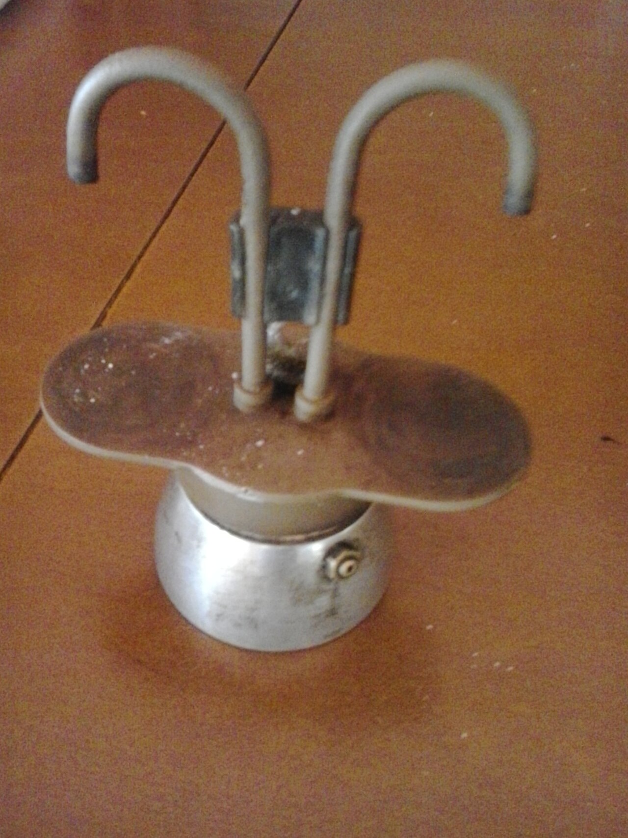 Traditional stovetop cafetera coffee pot brewing on a Puerto Rican kitchen stove with steam rising
