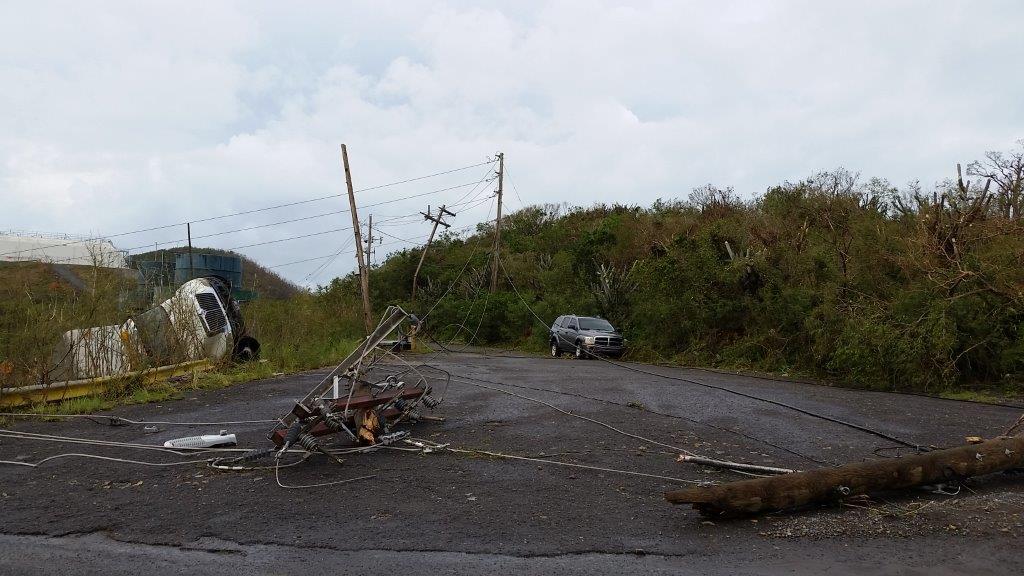 Damaged electrical infrastructure after Hurricane Fiona with collapsed power lines and poles (Wikimedia: St. Thomas power system down after Hurricane Irma (37055916056).jpg, CC BY 2.0)