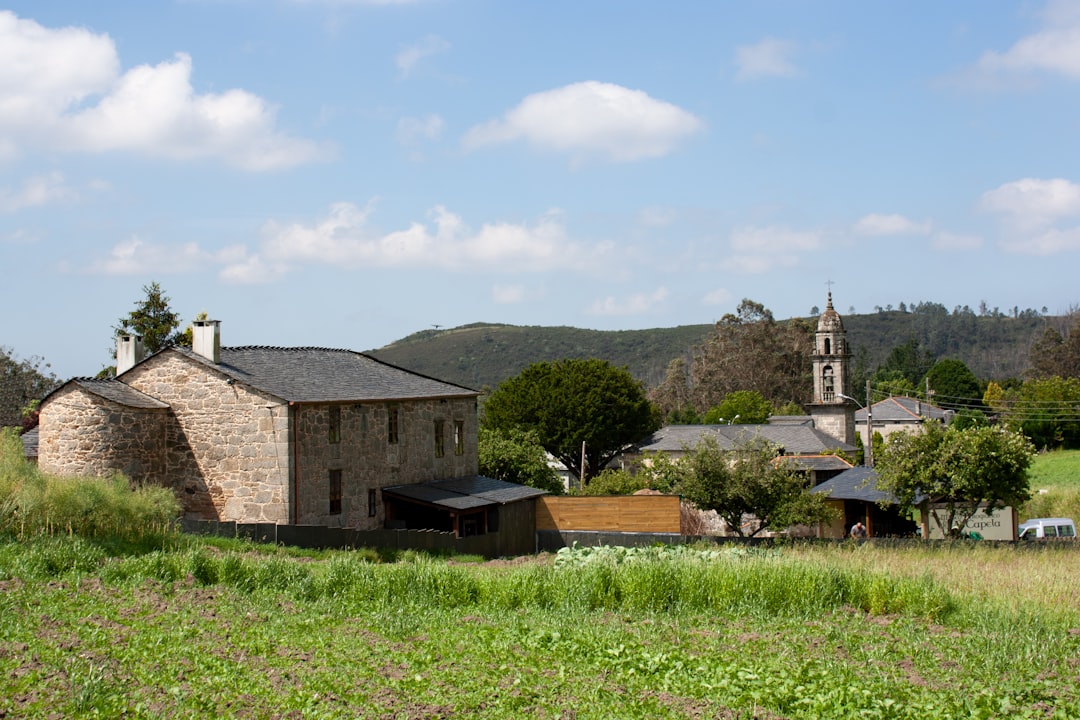 Casa Pueblo headquarters building in Adjuntas, traditional Puerto Rican wooden architecture painted in warm yellow and white, solar panels visible on the roof, mountains rising in the background
