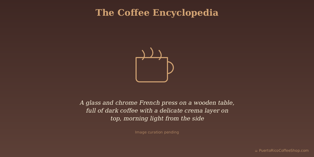 A glass and chrome French press on a wooden table, full of dark coffee with a delicate crema layer on top, morning light from the side
