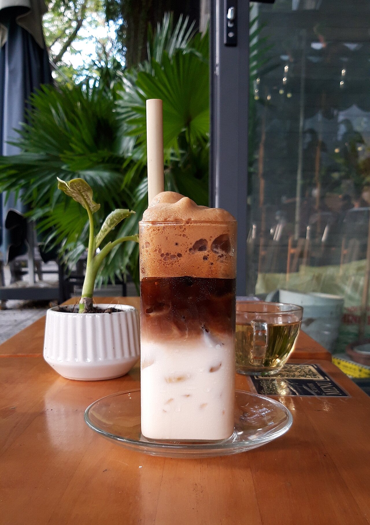 tall glass iced coffee with condensed milk close up
