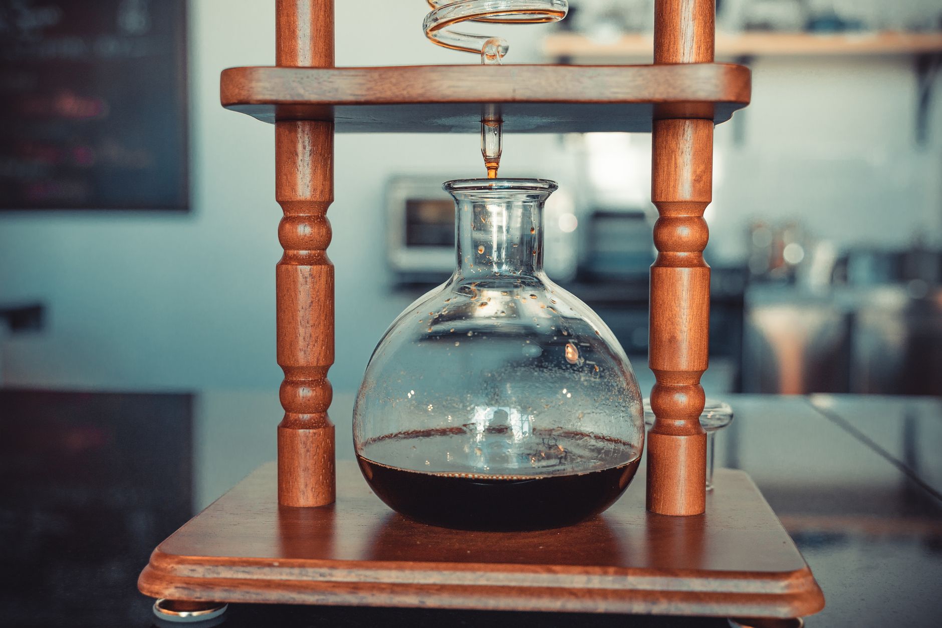 A Kyoto-style slow-drip cold brew tower with coffee dripping into a glass carafe