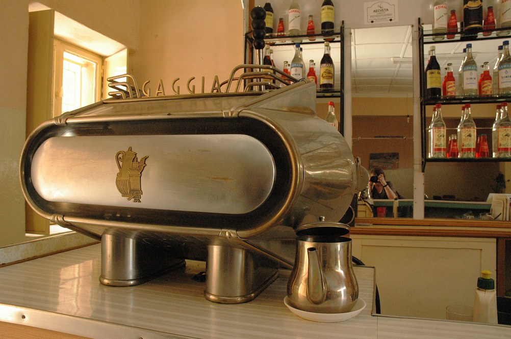 A vintage Gaggia lever espresso machine on a bar counter