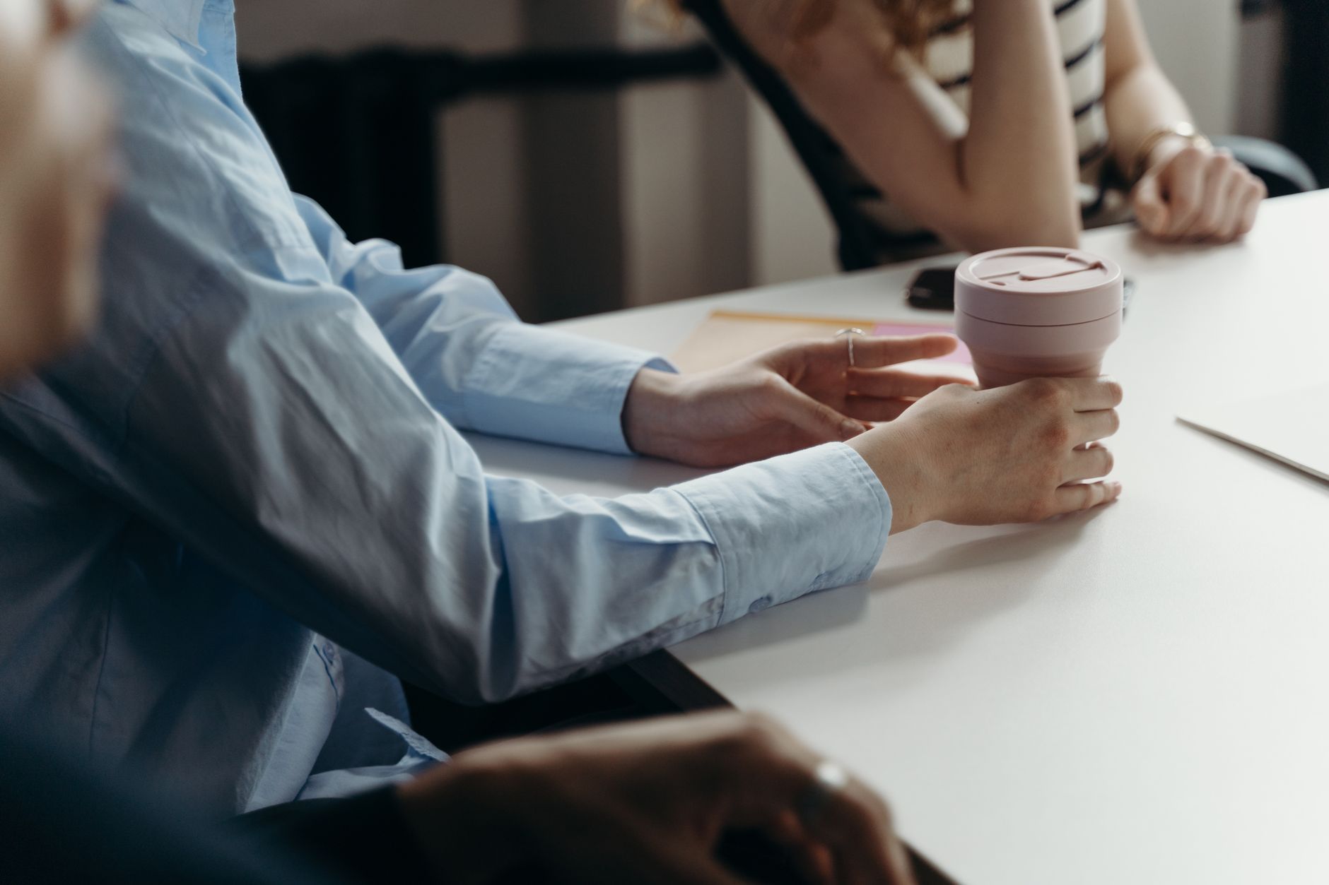 Colleagues with coffee cups during a workplace meeting