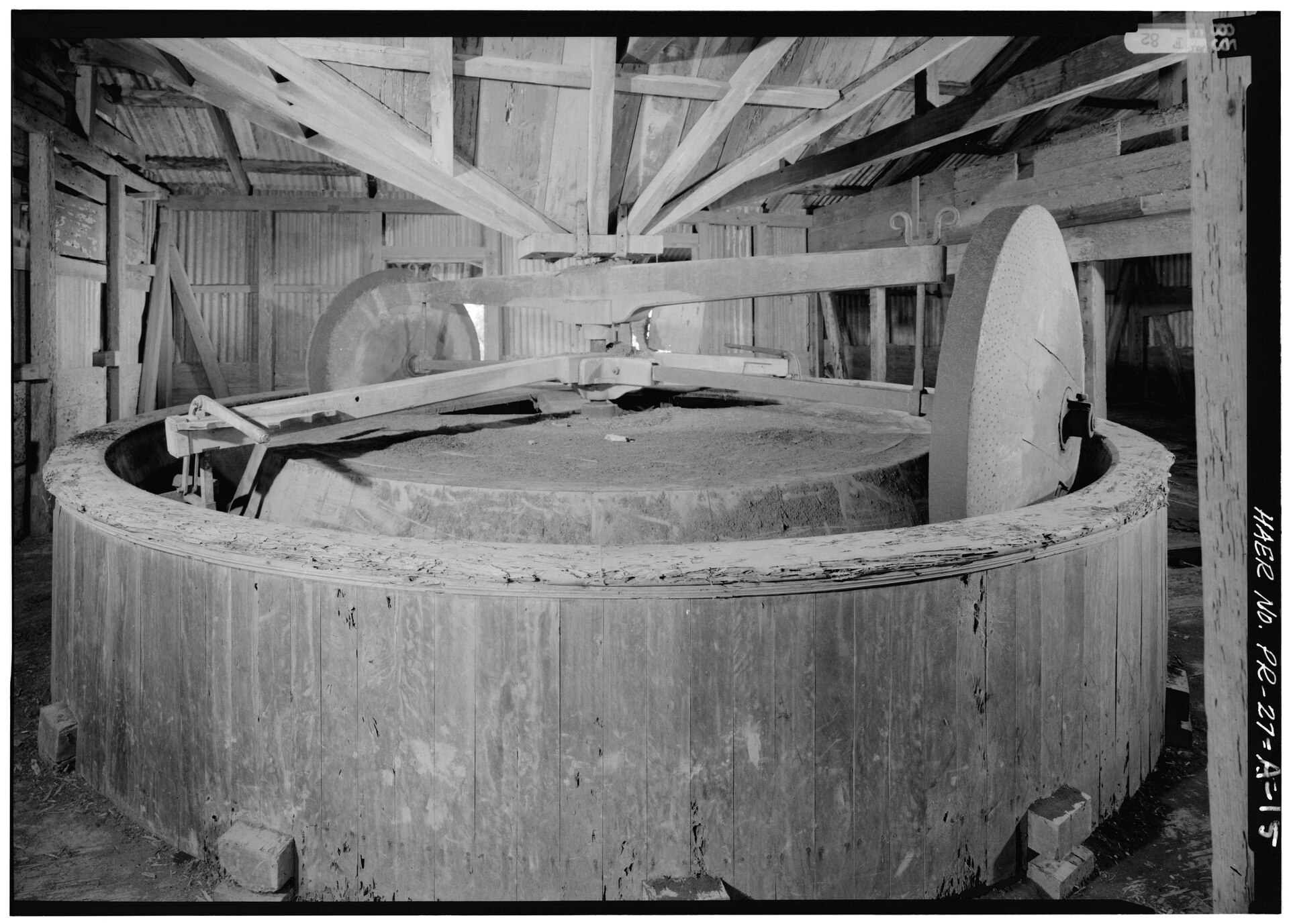 The coffee husking mill at Hacienda Santa Clara, Yauco — the circular stone husking basin, drive shaft and runner stone
