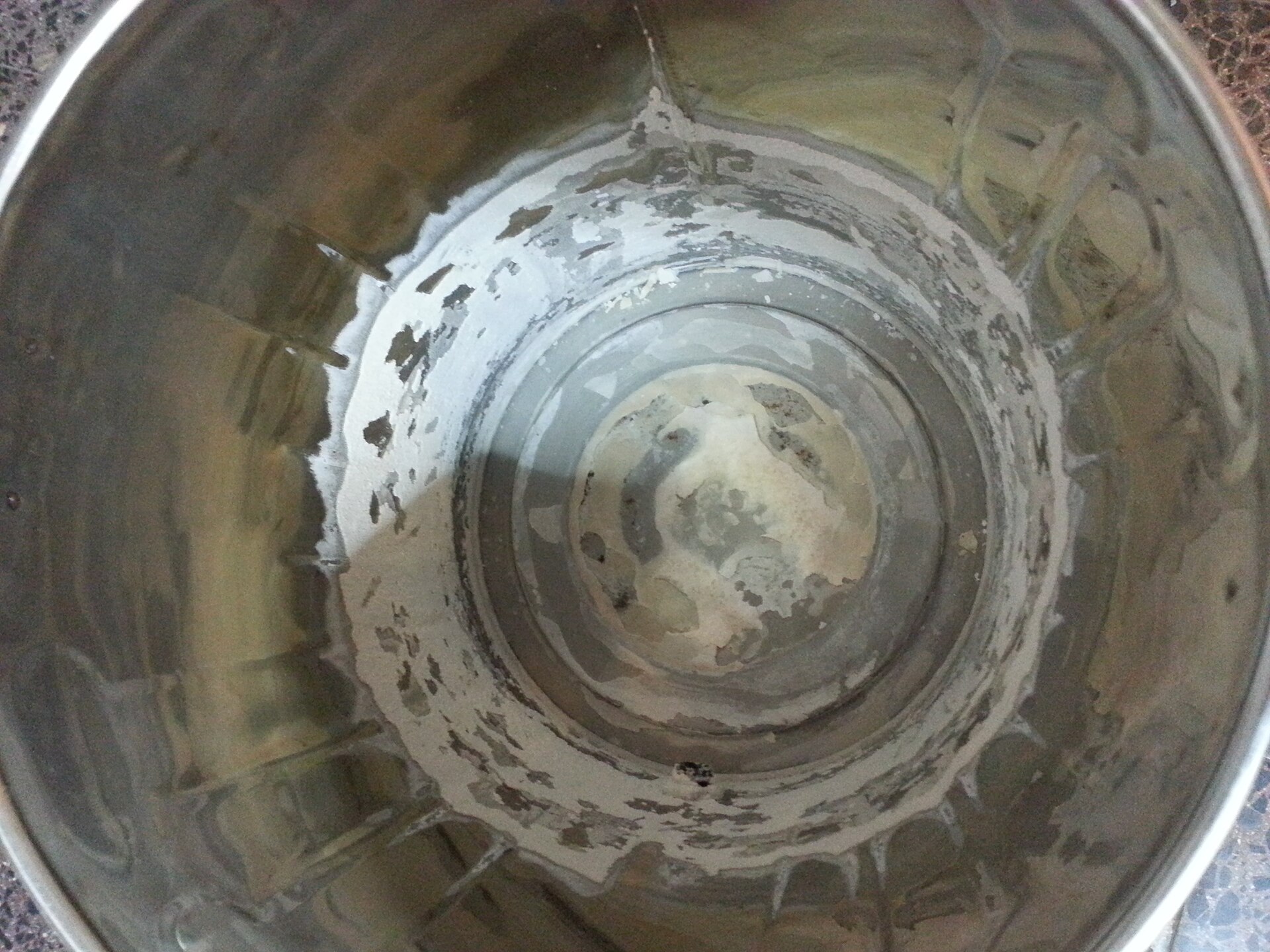 The interior of a stainless steel kettle showing a ring of limescale deposit.