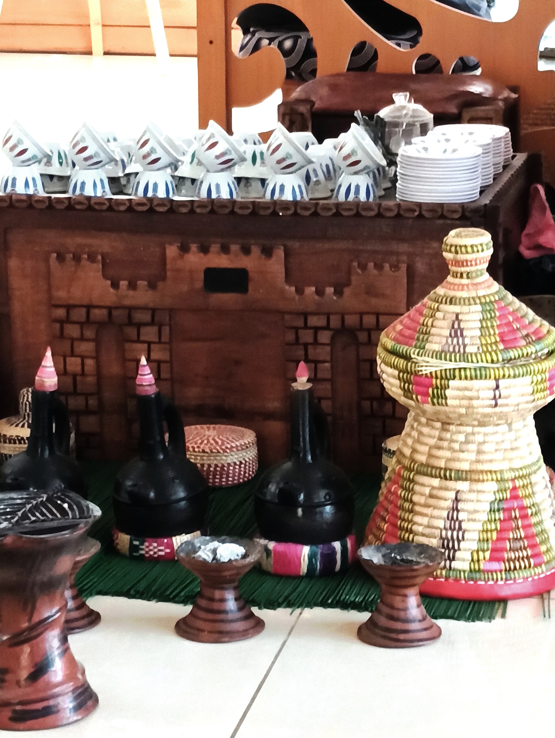 Jebena pots and rows of small finjan cups used for the three rounds of the ceremony