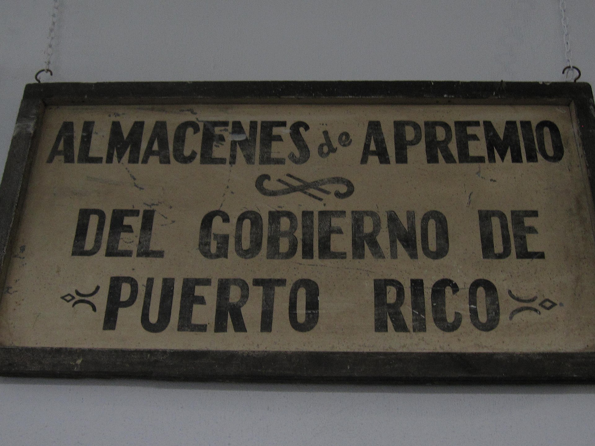 Painted sign reading Almacenes de Apremio del Gobierno de Puerto Rico, from the government coffee warehouses, on display at the Coffee Museum in Ciales, Puerto Rico