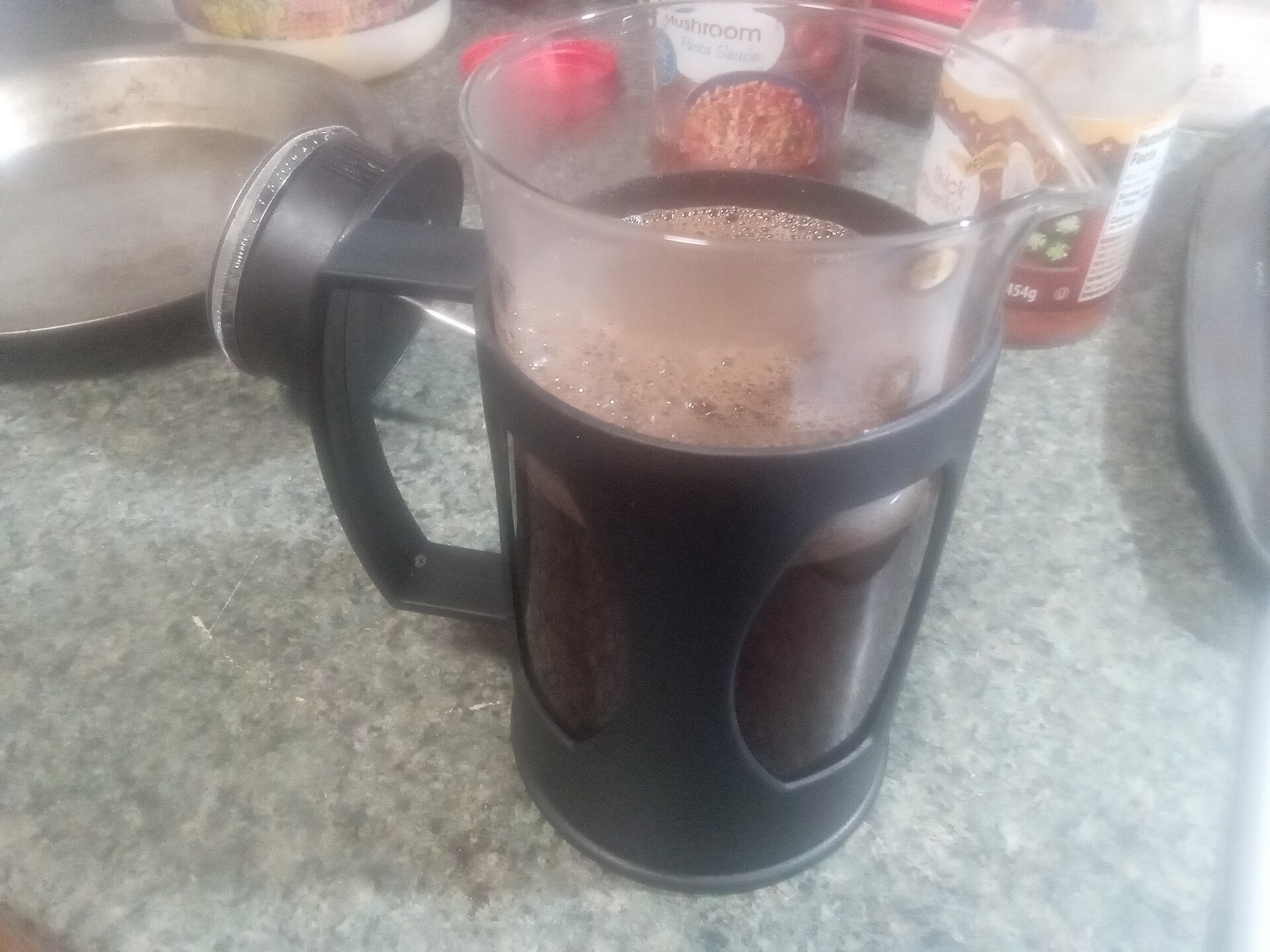 A French press of freshly brewed coffee on a kitchen counter