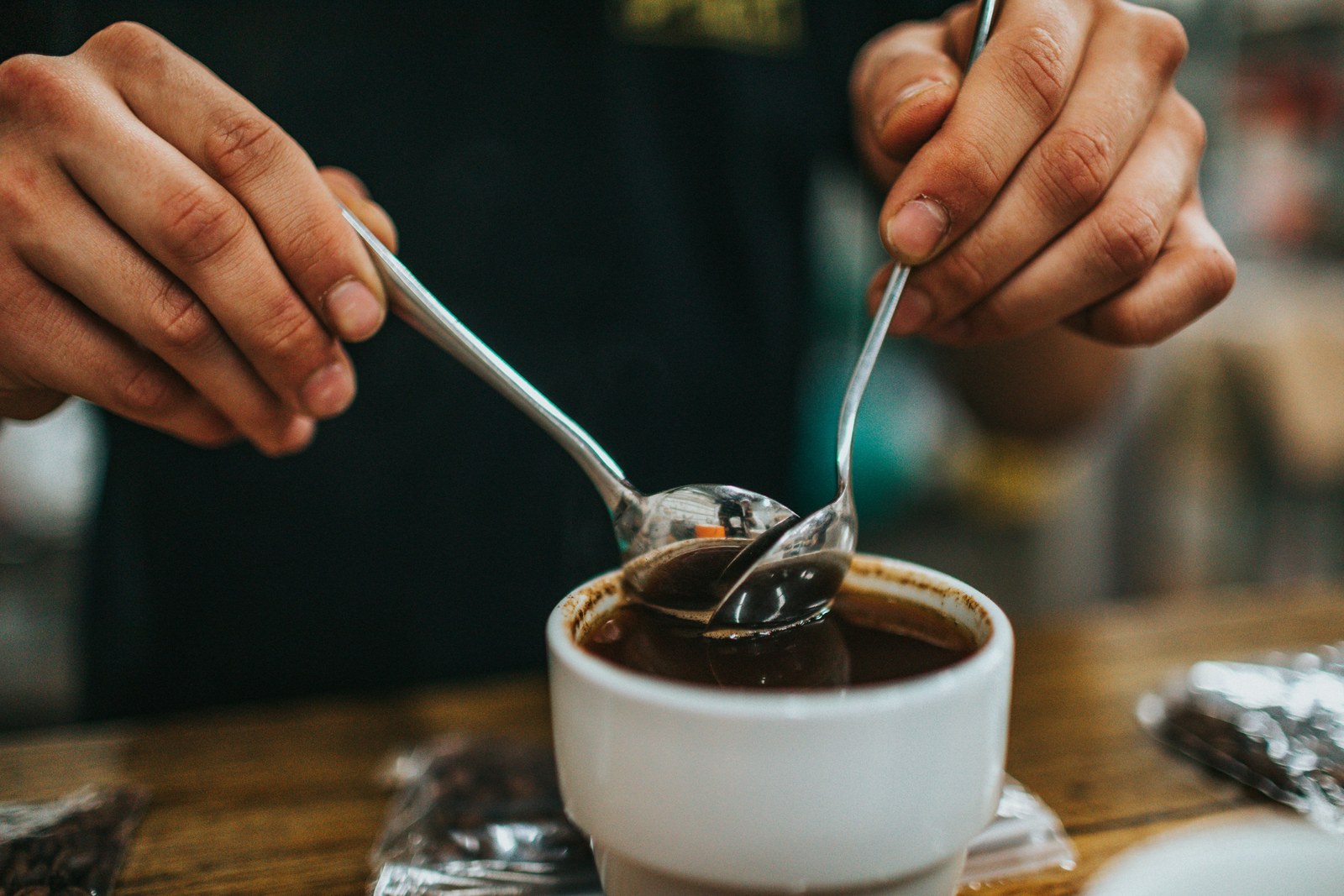 Two spoons dipped into a cupping bowl.