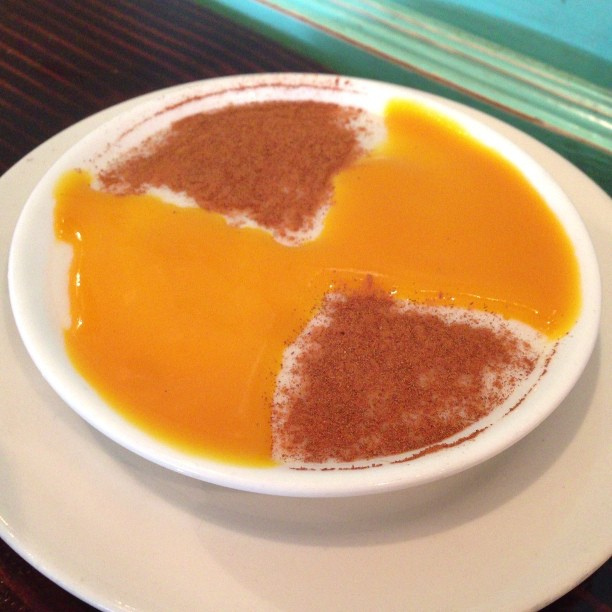 Tembleque, a creamy coconut pudding, with mango sauce and cinnamon.
