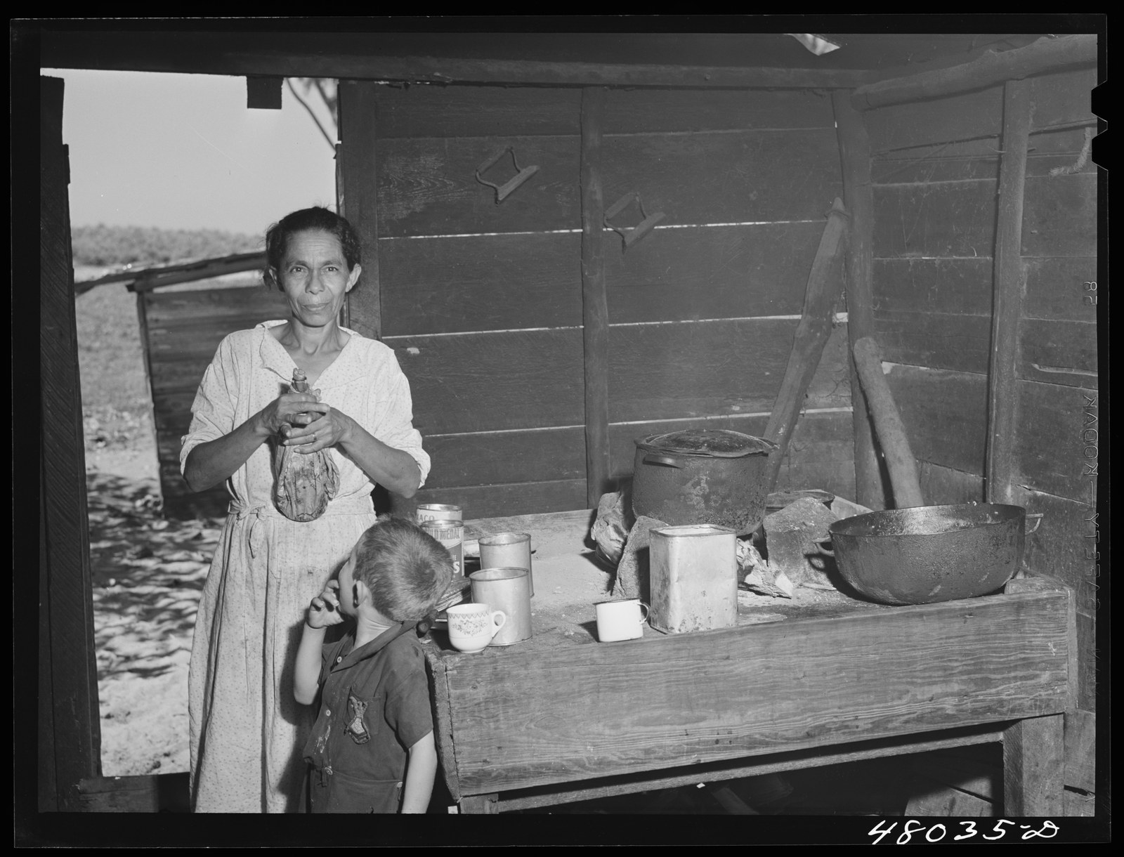 A farm woman near Arecibo, Puerto Rico, preparing bottles of coffee to take to family members working in the fields. Photographed by Jack Delano in 1942 for the Farm Security Administration.